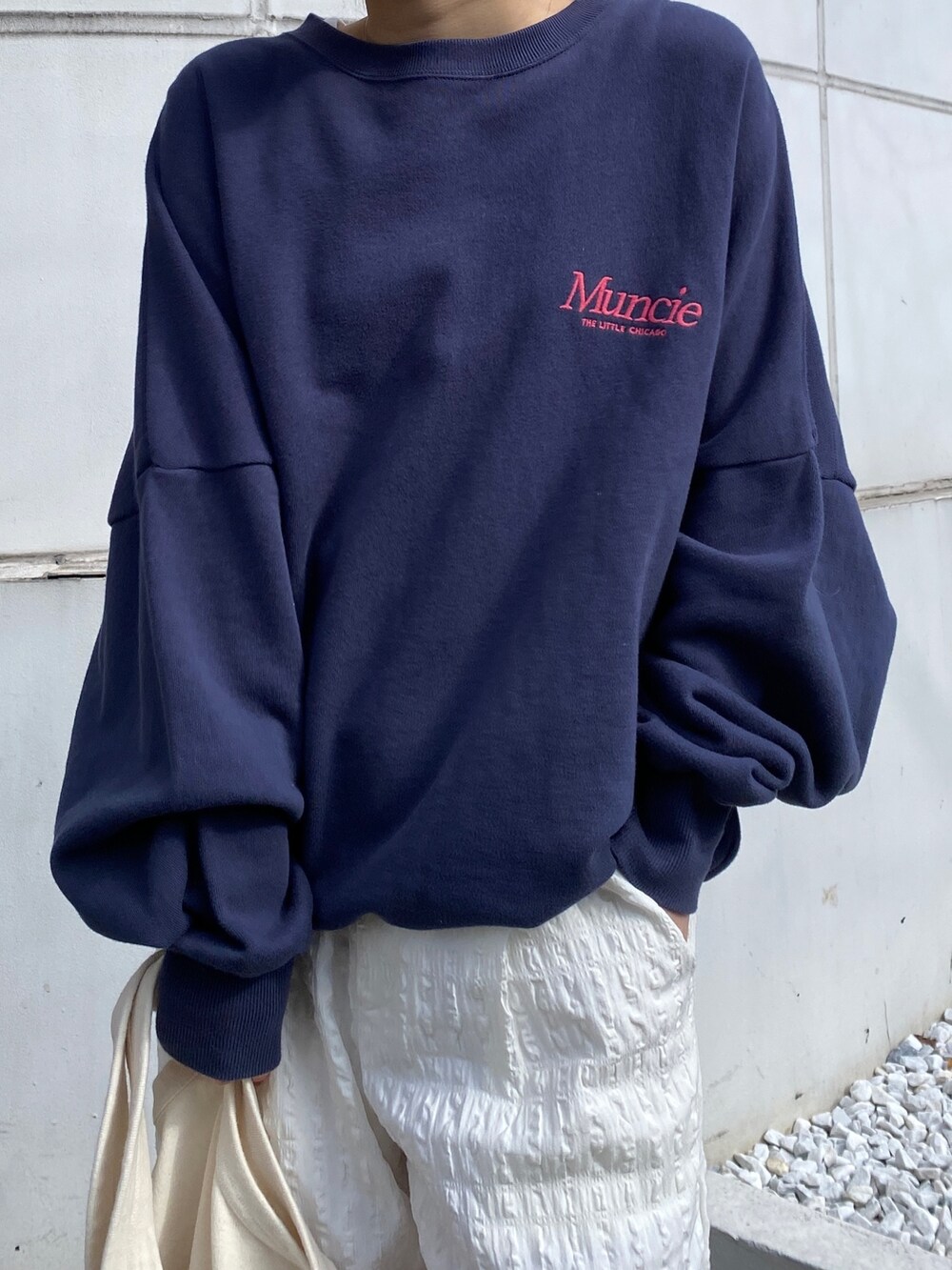 ブルー系のスウェット、ホワイト系のその他パンツ、グリーン系のトートバッグを着用したレディースの冬コーディネートの3枚目の写真