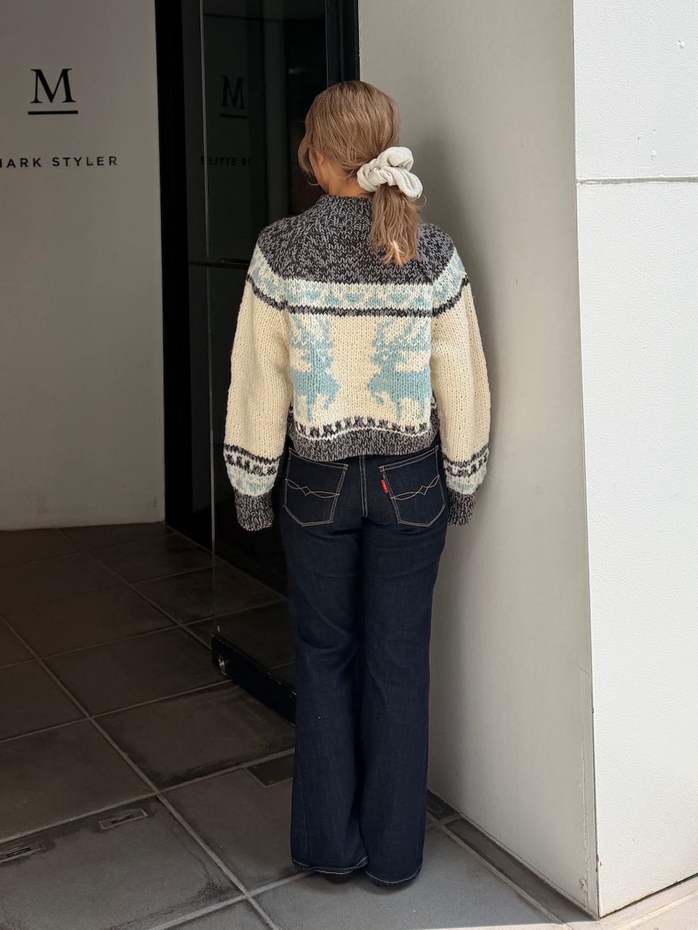 グレー系のニット/セーター、ブルー系のデニムパンツ、ブラウン系のブーツを着用したレディースの秋コーディネートの3枚目の写真