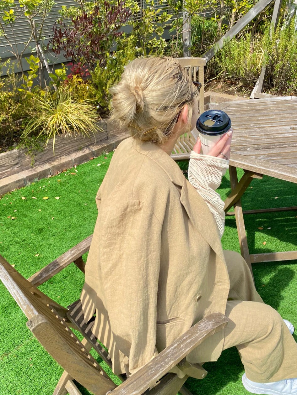 ホワイト系のタンクトップ、ベージュ系のテーラードジャケット、ベージュ系のその他パンツを着用したレディースの春コーディネートの7枚目の写真