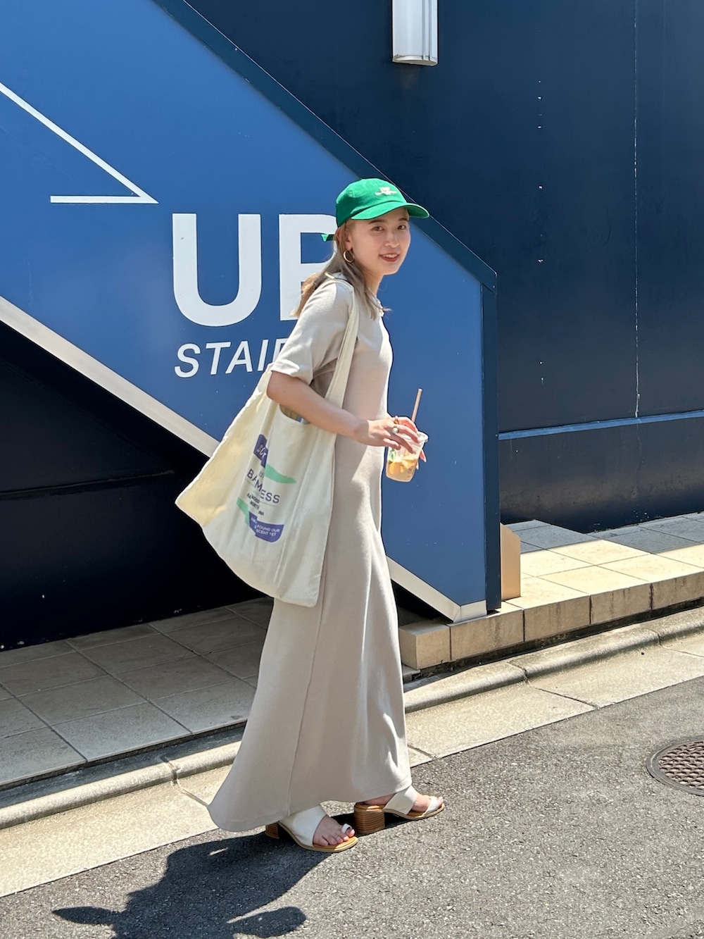 グレー系のワンピース、グリーン系のキャップを着用したレディースの夏コーディネートの5枚目の写真