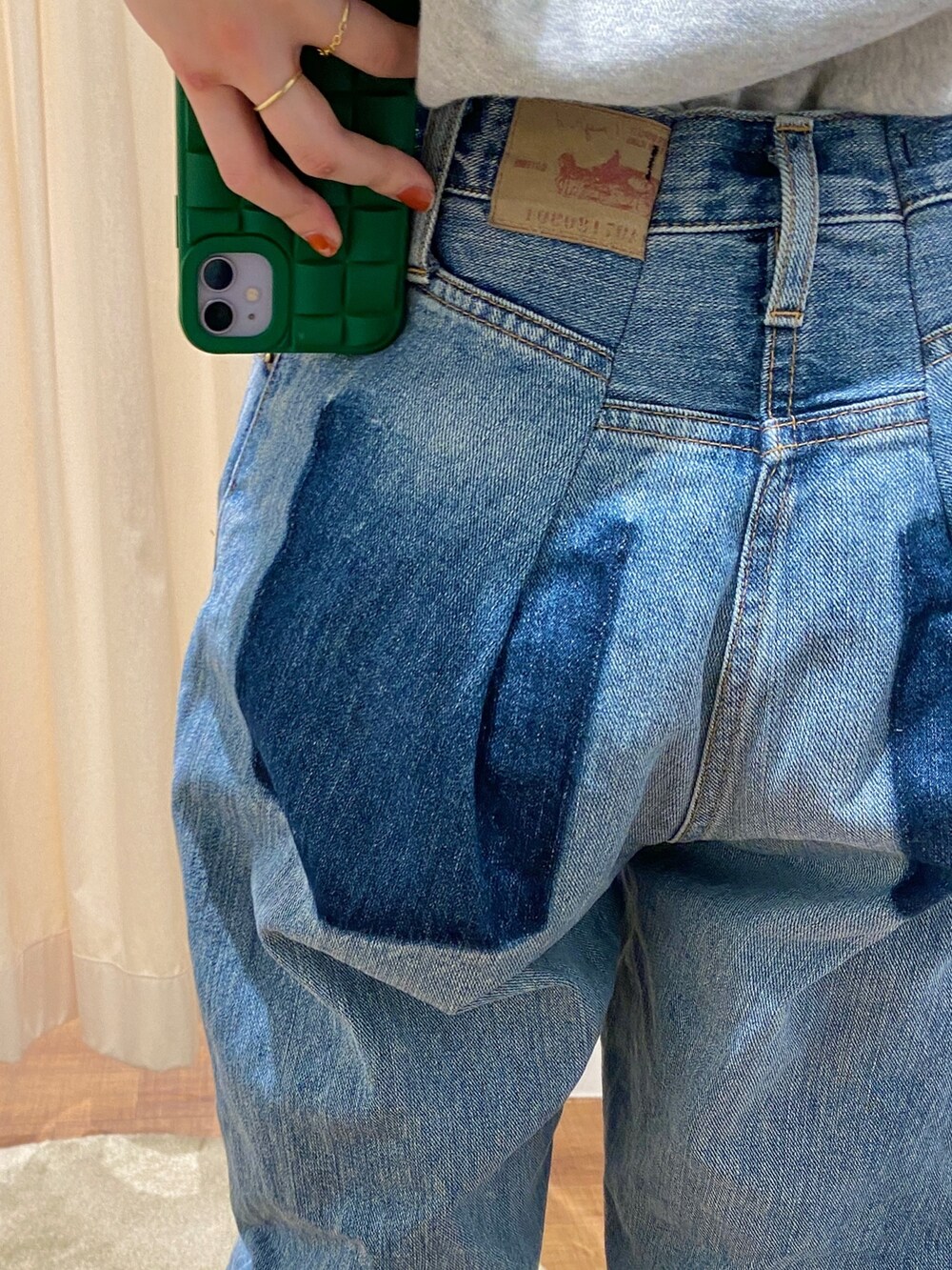 グレー系のスウェット、ブルー系のデニムパンツを着用したレディースの冬コーディネートの3枚目の写真