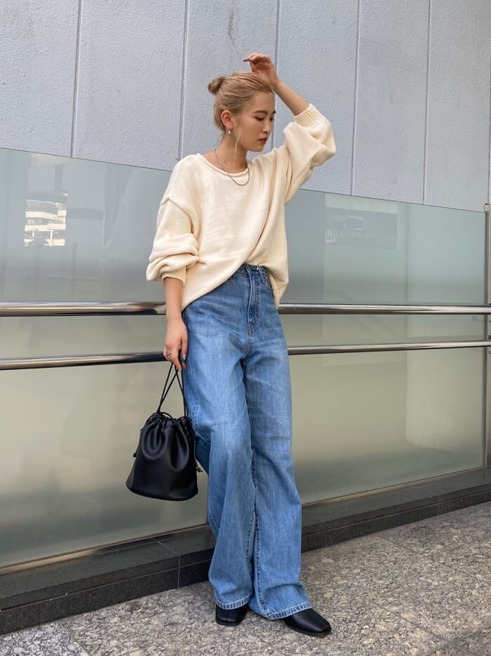 ブルー系のデニムパンツ、ブラック系のブーツ、ブラック系のハンドバッグを着用したレディースの秋コーディネートの7枚目の写真