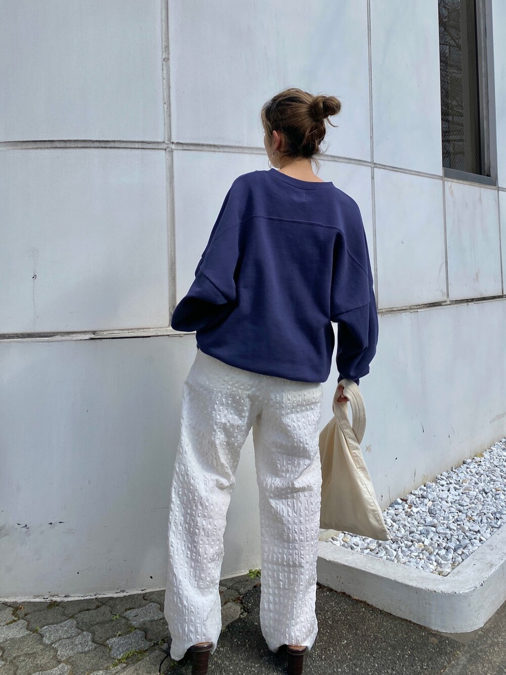 ブルー系のスウェット、ホワイト系のその他パンツ、グリーン系のトートバッグを着用したレディースの冬コーディネートの2枚目の写真