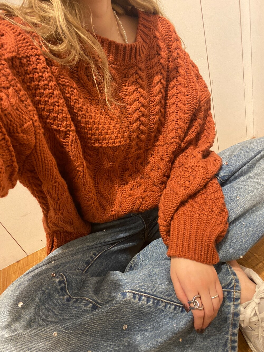 オレンジ系のニット/セーター、ブルー系のデニムパンツ、ブラック系のニットキャップ/ビーニーを着用したレディースの秋コーディネートの4枚目の写真