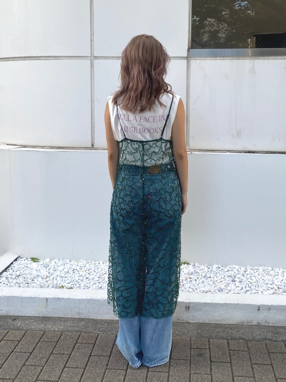 ブルー系のデニムパンツ、ホワイト系のタンクトップ、グリーン系のワンピースを着用したレディースの夏コーディネートの3枚目の写真
