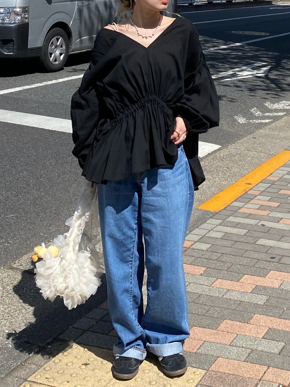 ブラック系のシャツ/ブラウス、ブルー系のデニムパンツ、ホワイト系のキャミソールを着用したレディースの春コーディネートの3枚目の写真