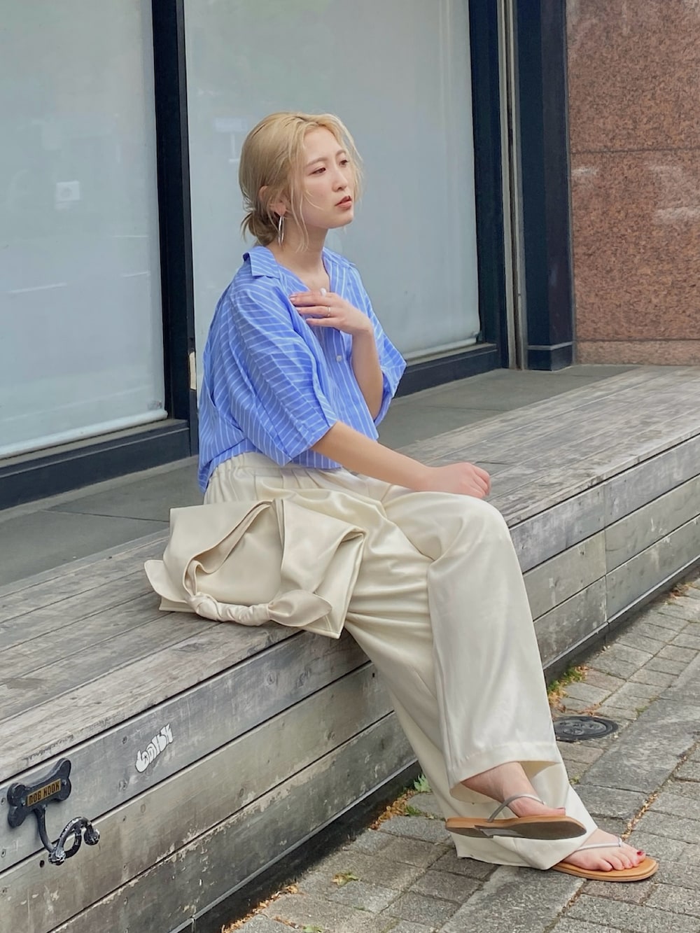ブルー系のシャツ/ブラウス、ホワイト系のその他パンツ、ホワイト系のハンドバッグを着用したレディースの春コーディネートの2枚目の写真