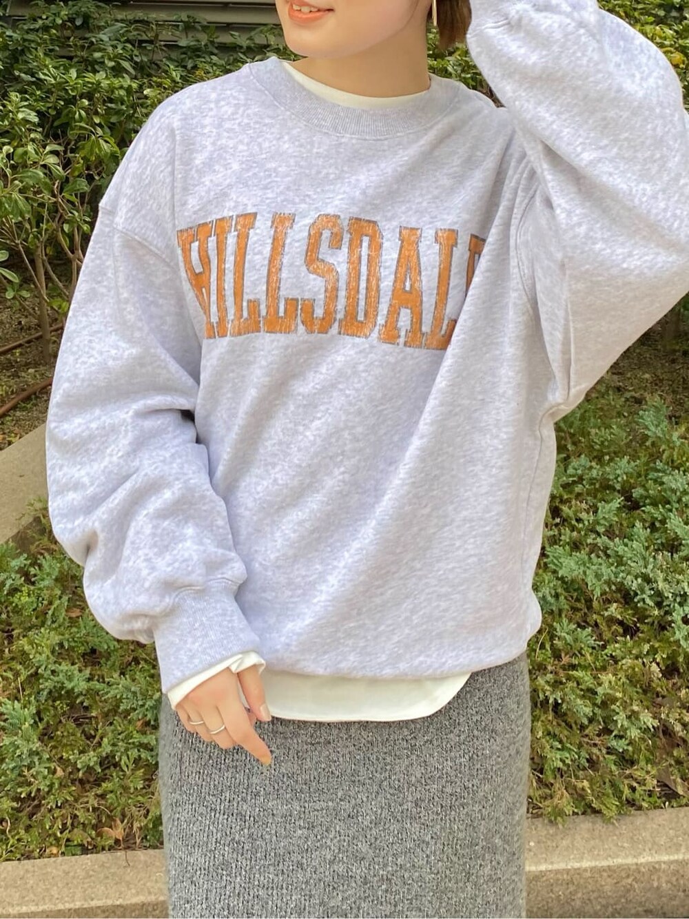 グレー系のスカート、グレー系のスウェット、ホワイト系のTシャツ/カットソーを着用したレディースの冬コーディネートの2枚目の写真