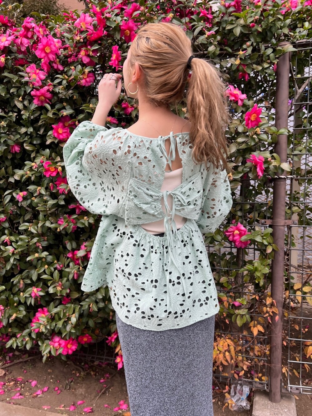 グリーン系のシャツ/ブラウス、ホワイト系のキャミソール、グレー系のスカートを着用したレディースの冬コーディネートの3枚目の写真