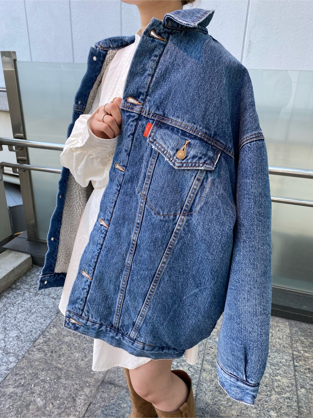 ベージュ系のブーツ、ブルー系のデニムジャケット、ホワイト系のシャツ/ブラウスを着用したレディースの冬コーディネートの6枚目の写真