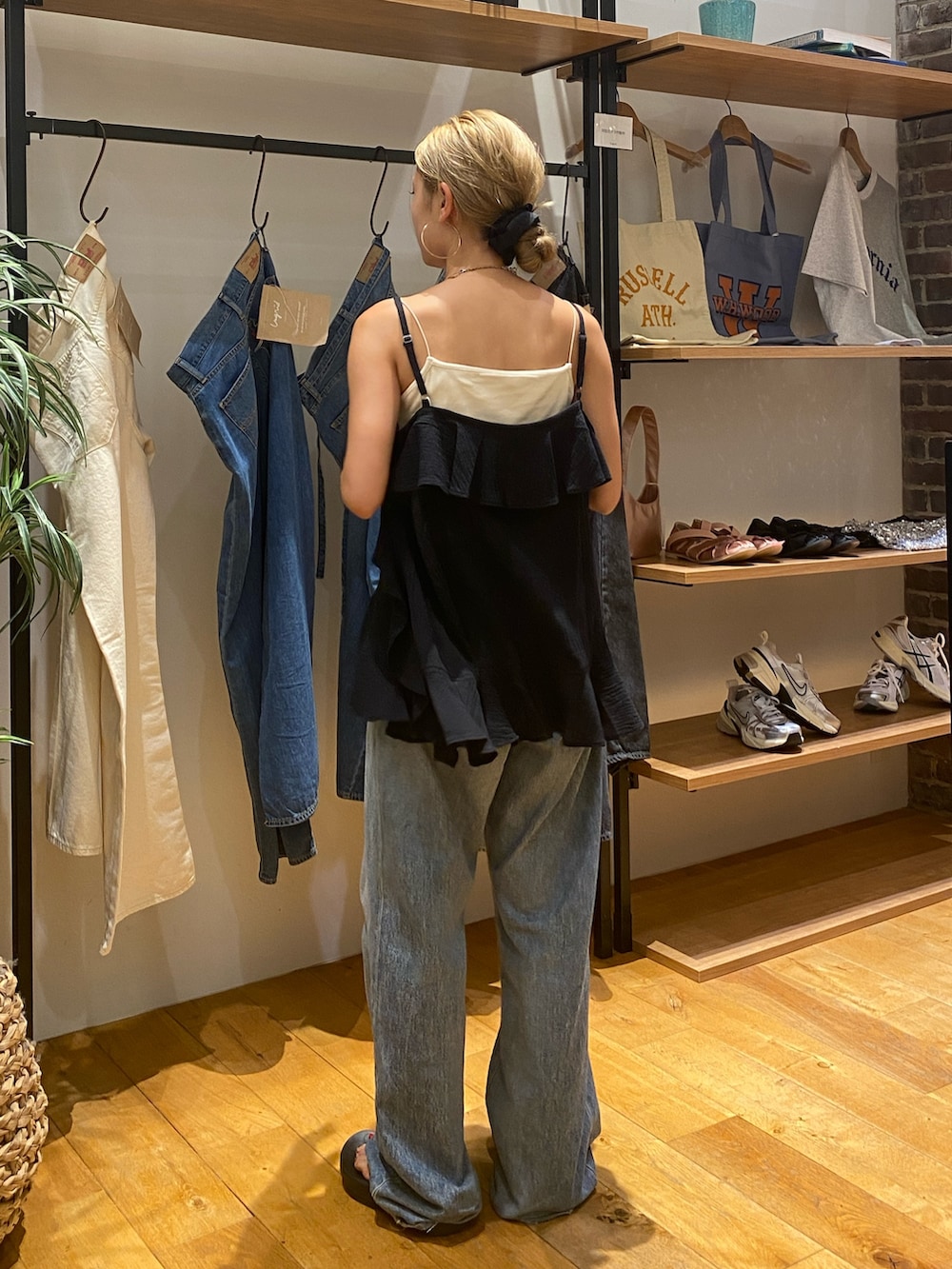 ブラック系のキャミソール、ホワイト系のキャミソール、ブルー系のデニムパンツを着用したレディースの夏コーディネートの4枚目の写真