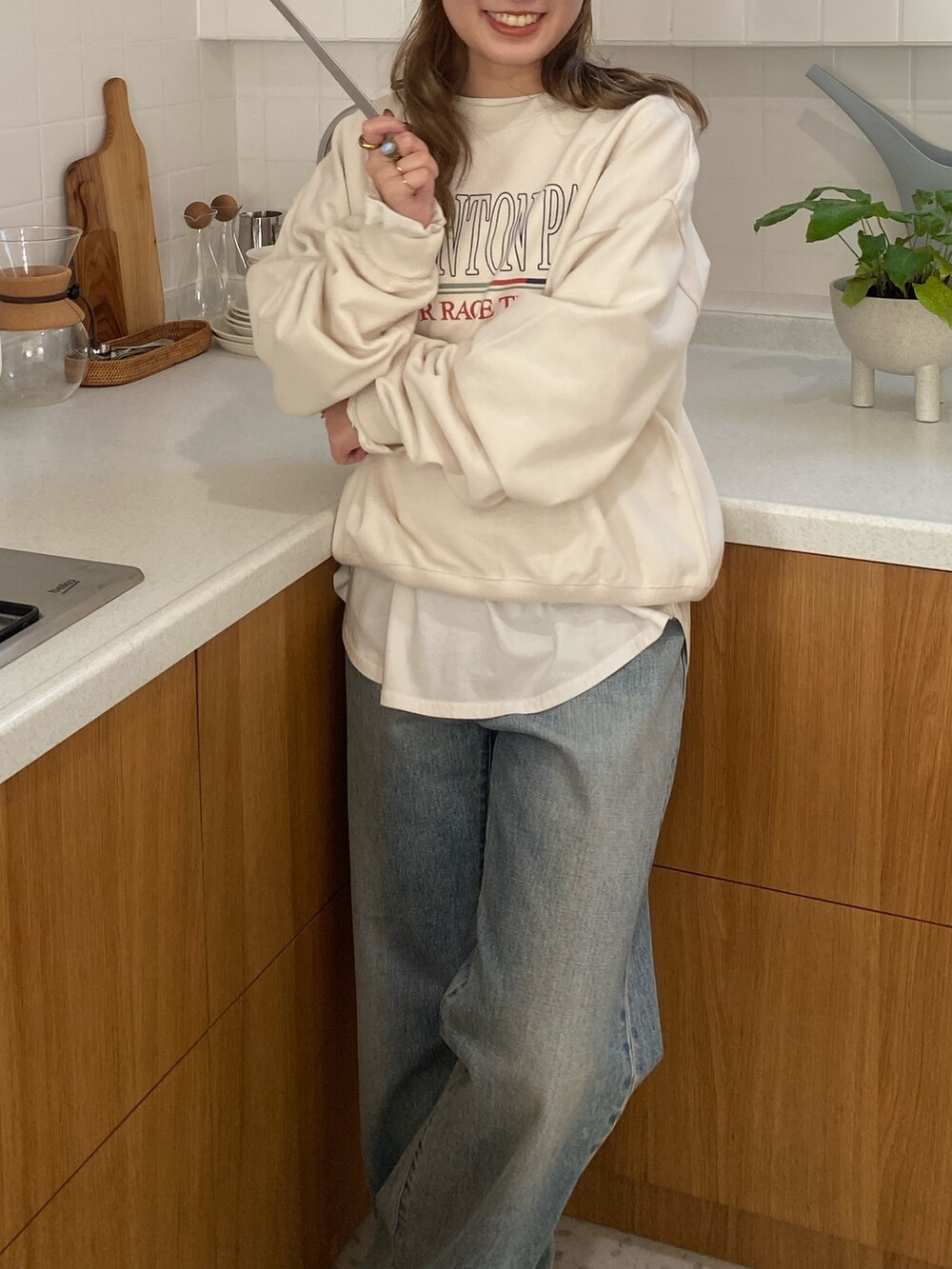 ホワイト系のスウェット、ホワイト系のTシャツ/カットソー、ブルー系のデニムパンツを着用したレディースの冬コーディネートの4枚目の写真