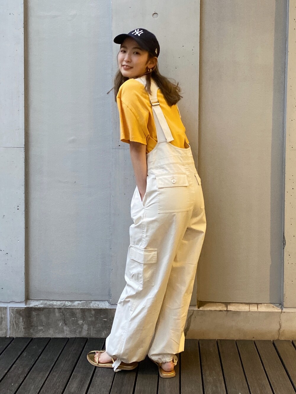 ホワイト系のつなぎ/オールインワン、イエロー系のTシャツ/カットソー、ゴールド系のサンダルを着用したレディースの春コーディネートの3枚目の写真