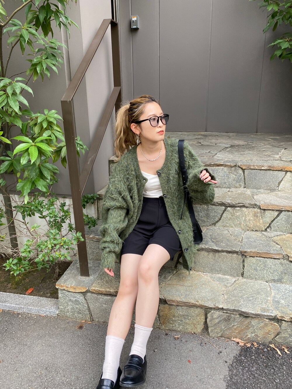 グリーン系のカーディガン/ボレロ、ブラック系のショルダーバッグ、ブラック系のローファーを着用したレディースの秋コーディネートの4枚目の写真