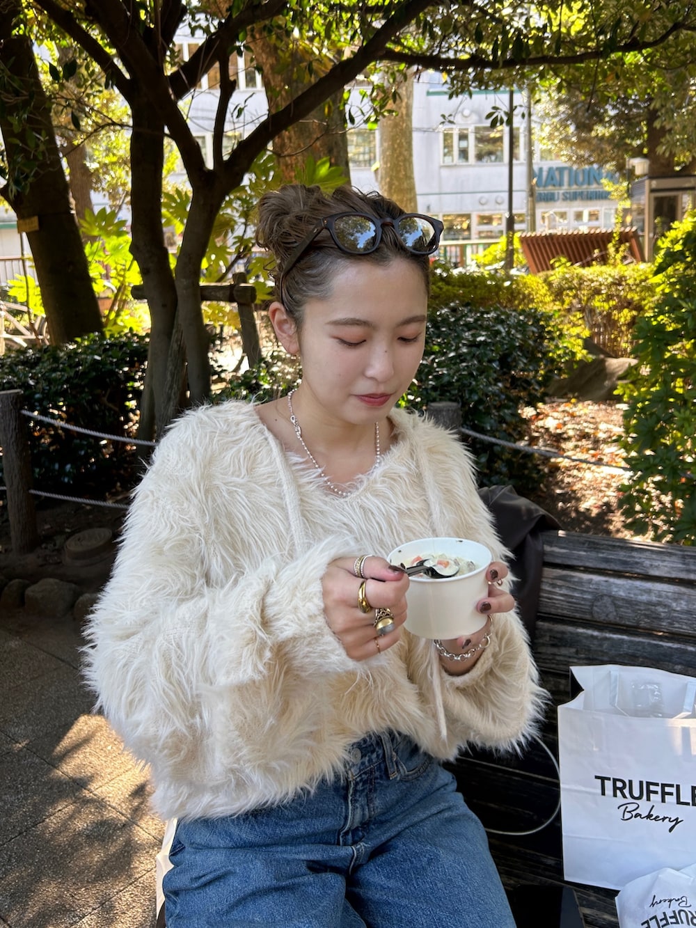 ホワイト系のニット/セーター、ブルー系のデニムパンツを着用したレディースの冬コーディネートの3枚目の写真