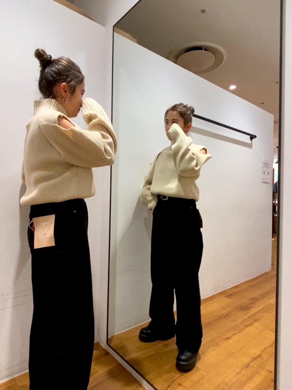 ブラック系のデニムパンツ、ブラック系のブーツ、ホワイト系のニット/セーターを着用したレディースの秋コーディネートの2枚目の写真