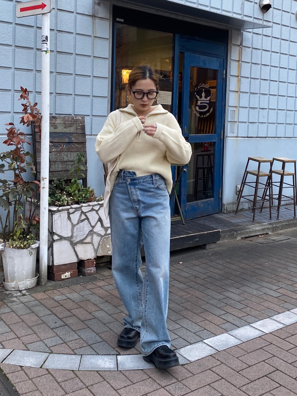 ホワイト系のニット/セーター、ブルー系のデニムパンツ、レッド系のトートバッグを着用したレディースの冬コーディネートの6枚目の写真