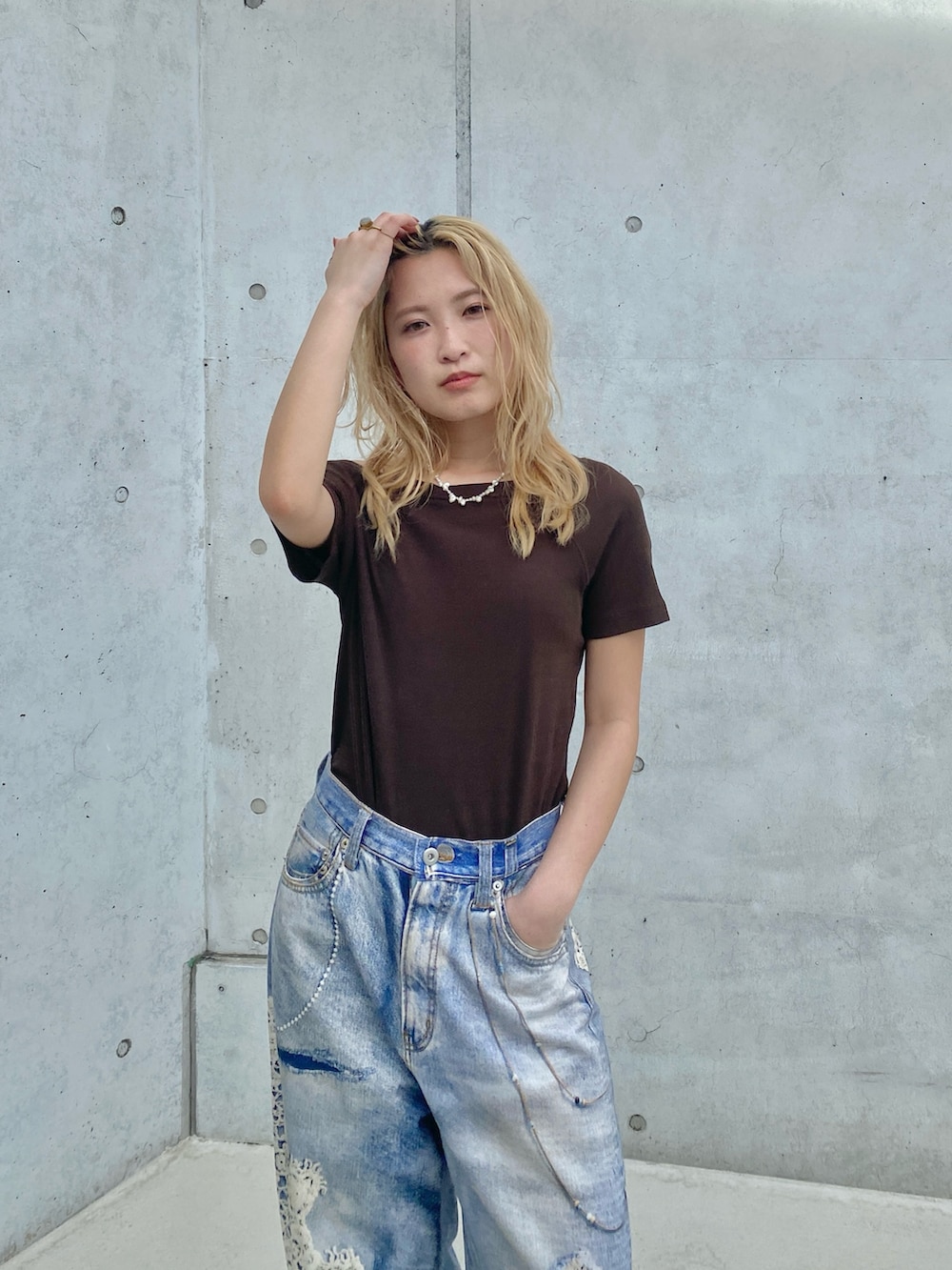 ブラウン系のTシャツ/カットソー、ブルー系のデニムパンツを着用したレディースの春コーディネートの4枚目の写真