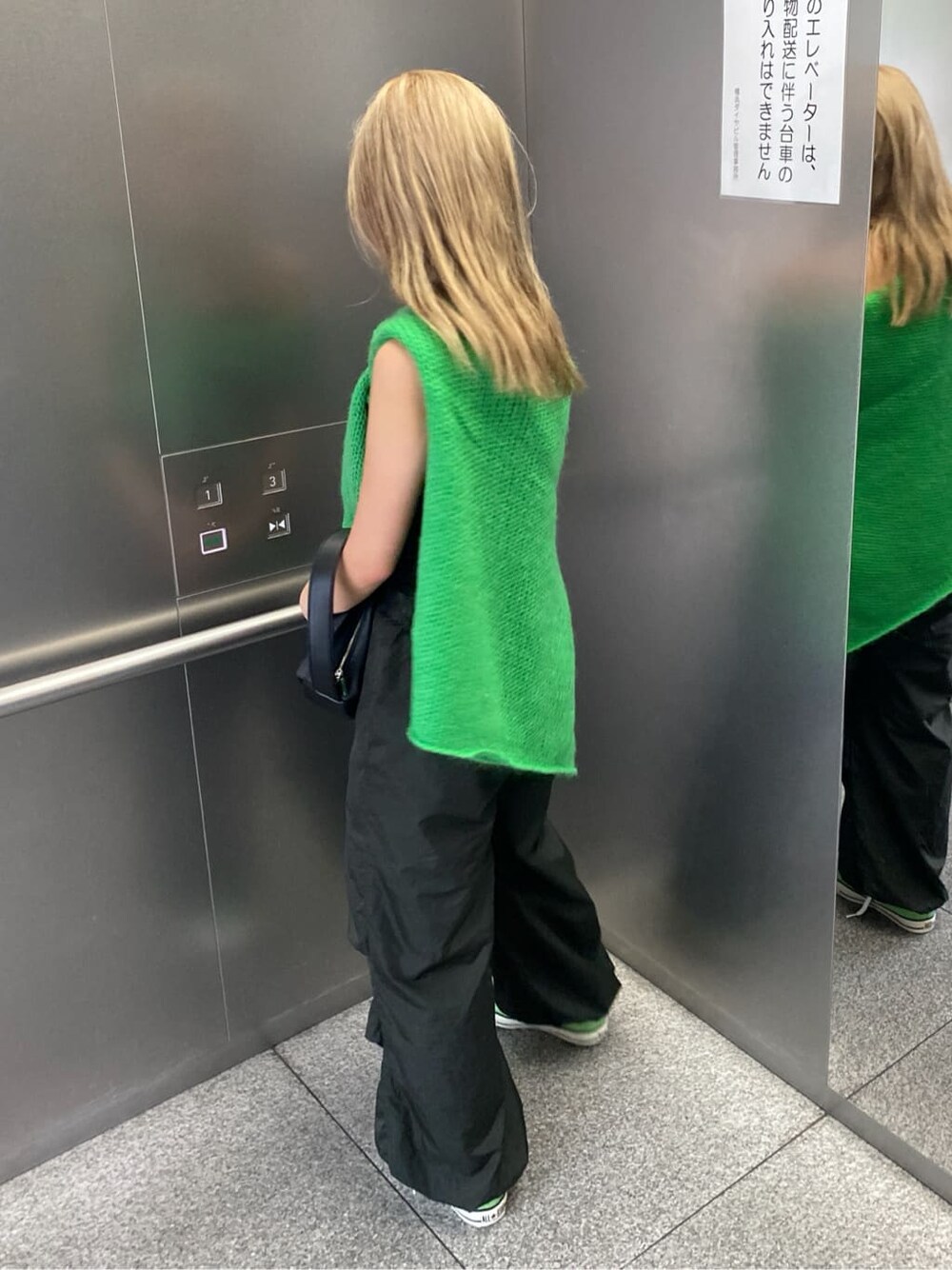 グリーン系のニット/セーター、グレー系のその他パンツを着用したレディースの秋コーディネートの4枚目の写真