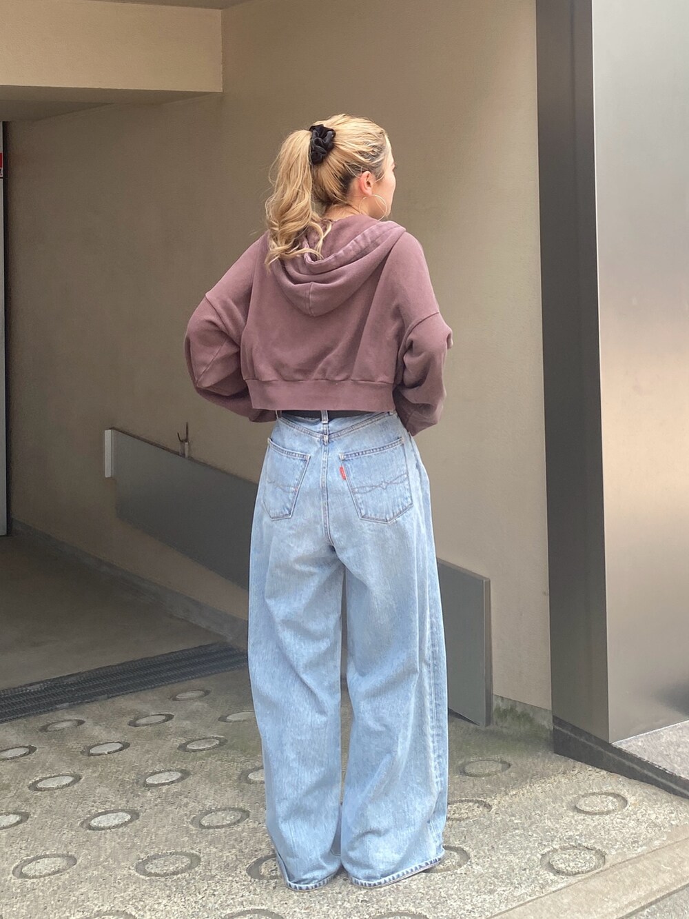 ブラウン系のパーカー、ブルー系のデニムパンツ、ブラウン系のローファーを着用したレディースの秋コーディネートの2枚目の写真