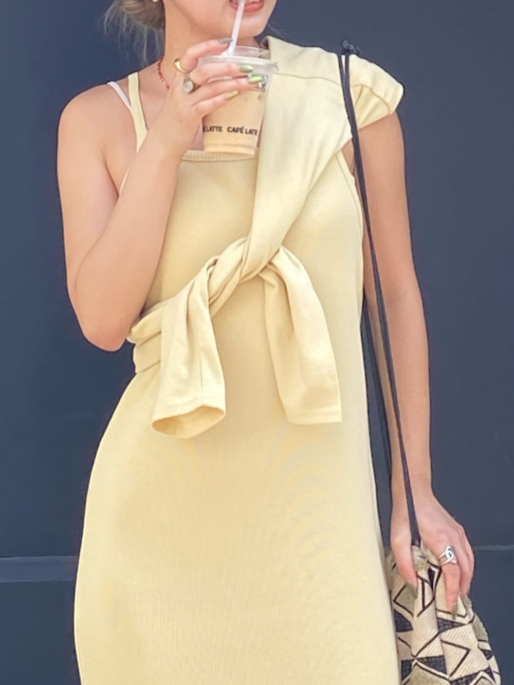 イエロー系のワンピース、レッド系のネックレスを着用したレディースの夏コーディネートの4枚目の写真