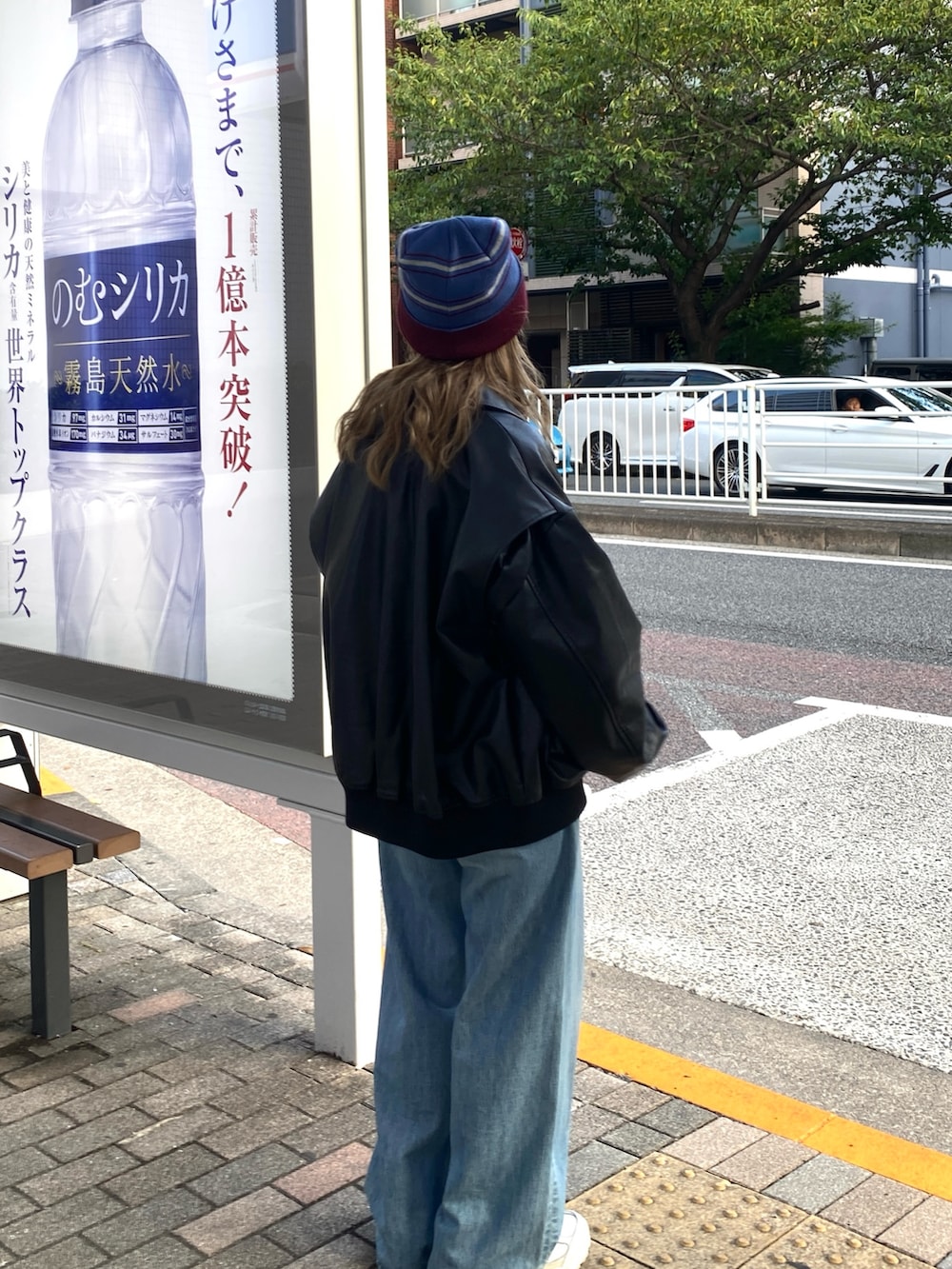 ブラック系のブルゾン、ホワイト系のTシャツ/カットソー、レッド系のトートバッグを着用したレディースの秋コーディネートの2枚目の写真