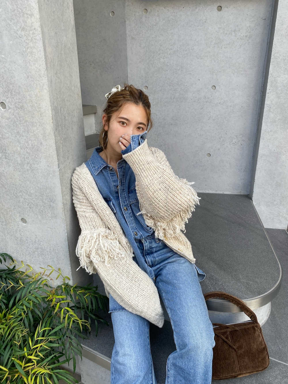 ホワイト系のカーディガン/ボレロ、ブルー系のシャツ/ブラウス、ブルー系のデニムパンツを着用したレディースの秋コーディネートの3枚目の写真