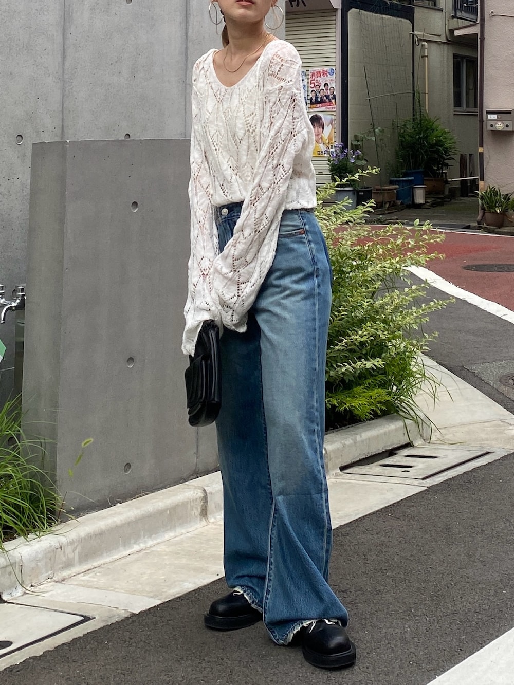 ホワイト系のニット/セーター、ブルー系のデニムパンツ、ブラック系のショルダーバッグを着用したレディースの夏コーディネートの2枚目の写真