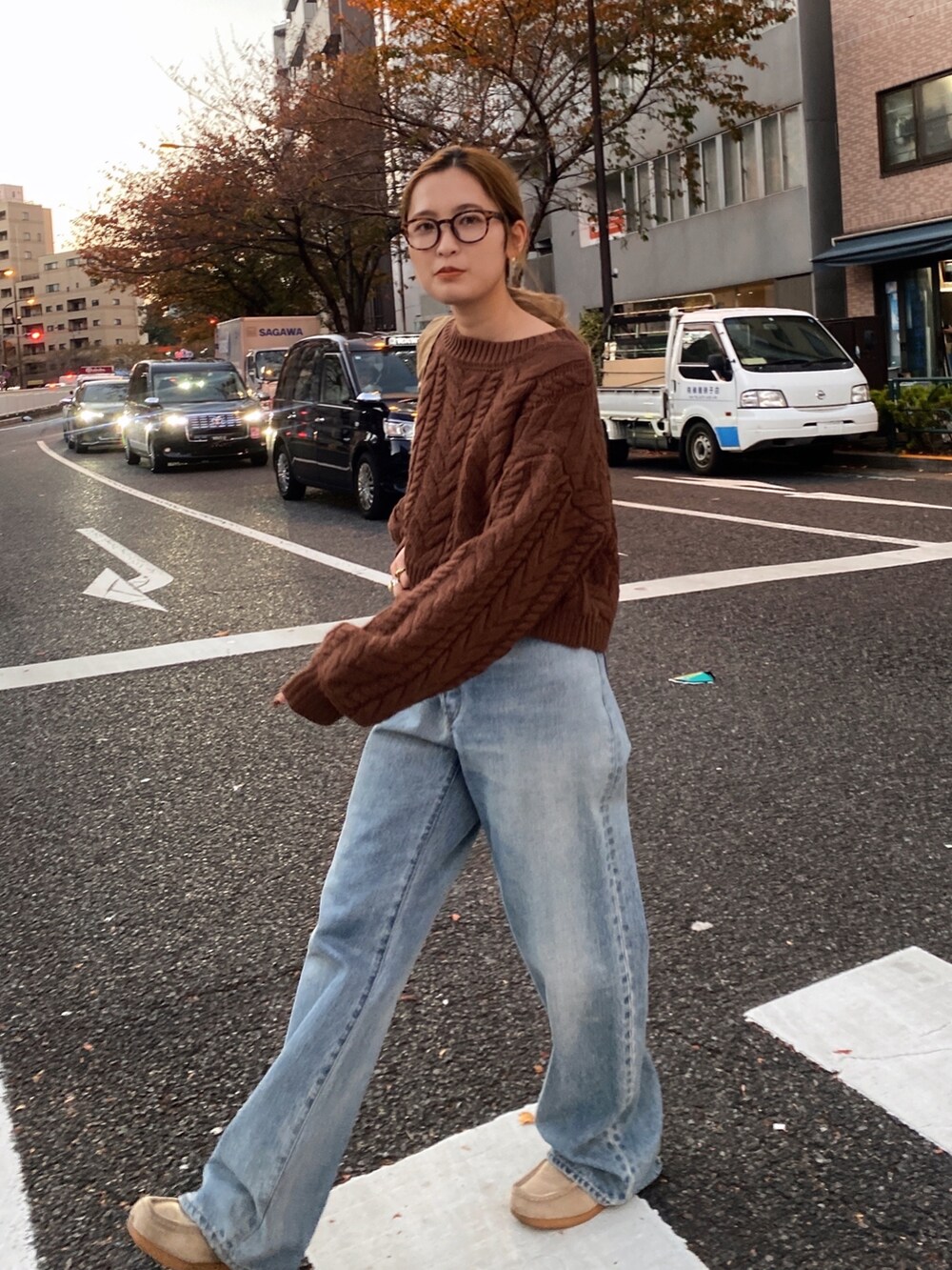 ブラウン系のニット/セーター、ブルー系のデニムパンツ、ベージュ系のハンドバッグを着用したレディースの冬コーディネートの6枚目の写真