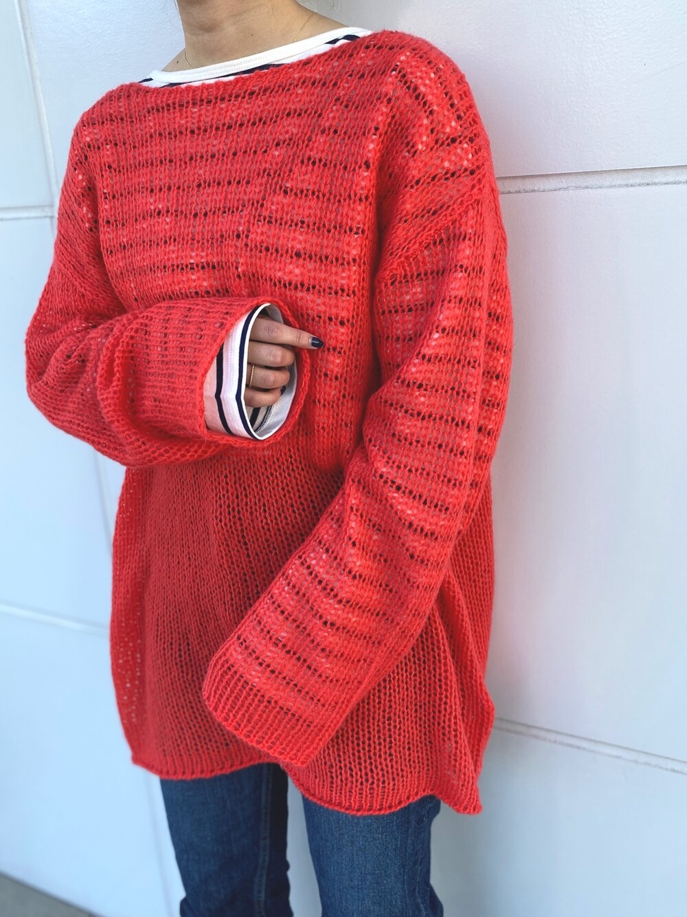 オレンジ系のニット/セーター、ブルー系のTシャツ/カットソーを着用したレディースの冬コーディネートの7枚目の写真