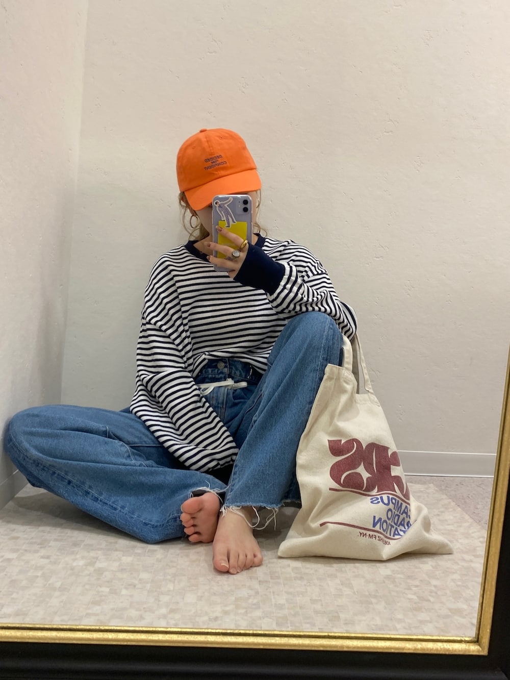 ブルー系のTシャツ/カットソー、ブルー系のデニムパンツ、レッド系のトートバッグを着用したレディースの冬コーディネートの2枚目の写真