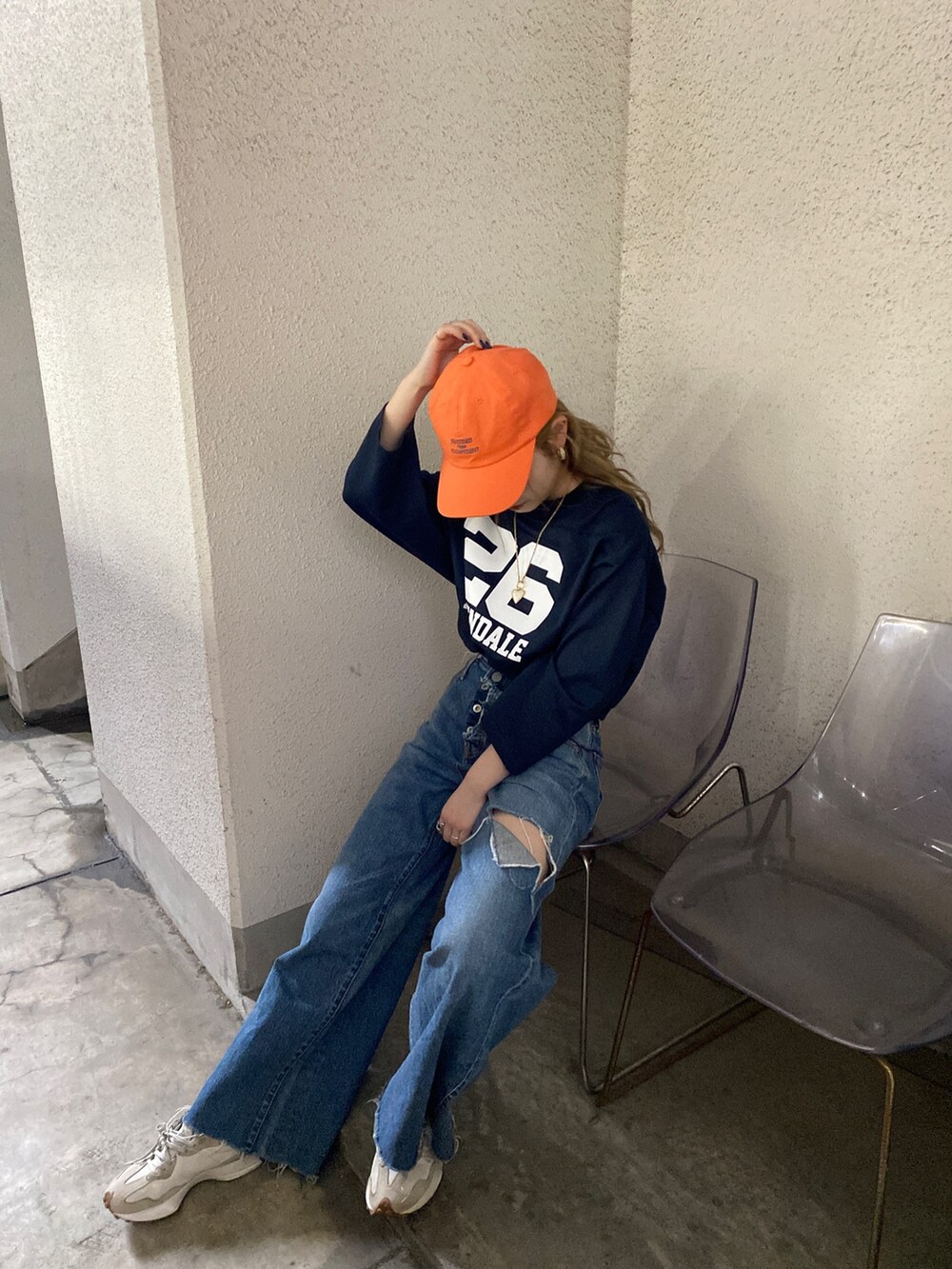 ブルー系のTシャツ/カットソー、ブルー系のデニムパンツ、オレンジ系のキャップを着用したレディースの春コーディネートの3枚目の写真