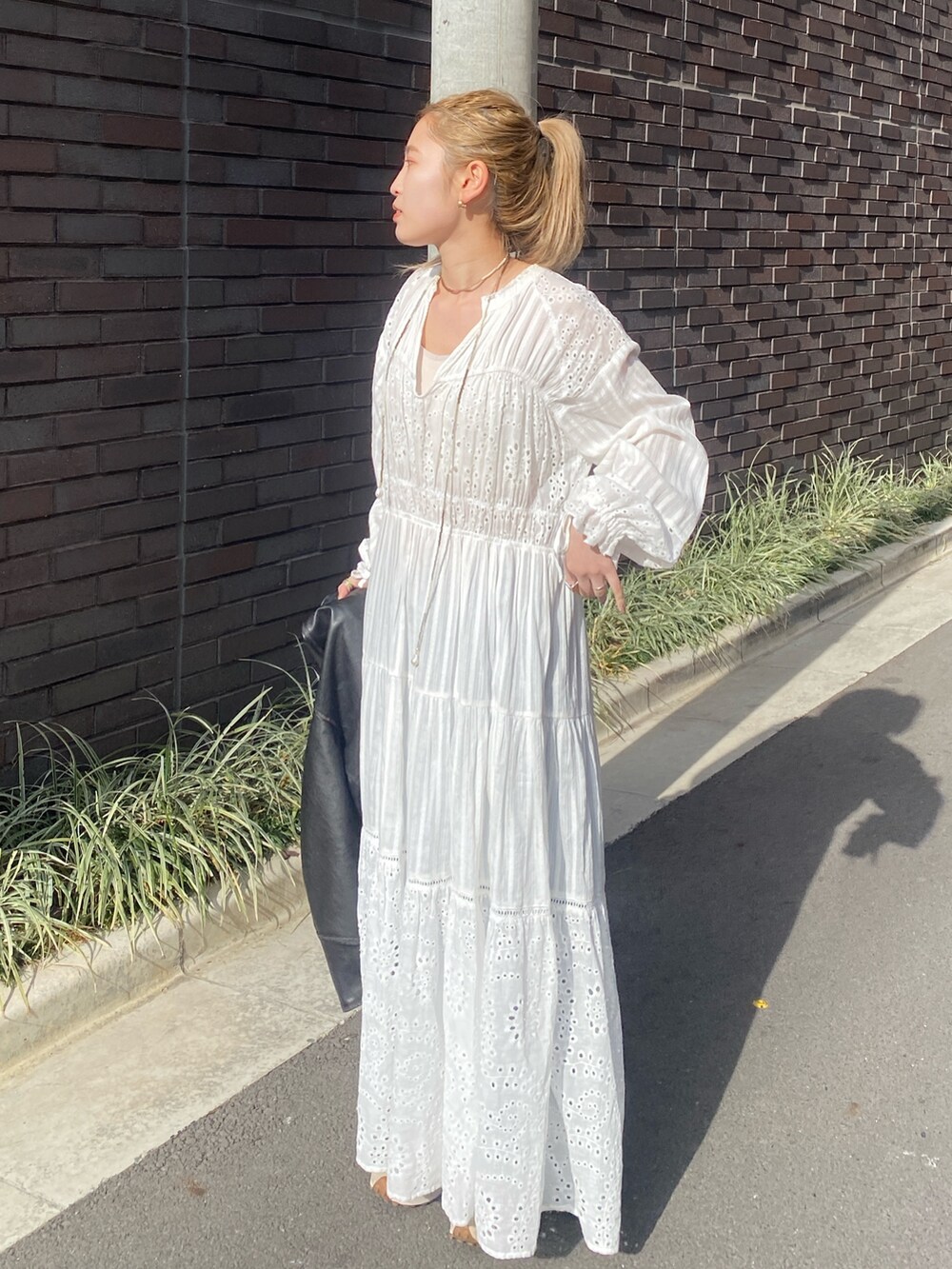 ブラック系のブルゾン、ホワイト系のワンピース、ブルー系のデニムパンツを着用したレディースの冬コーディネートの5枚目の写真