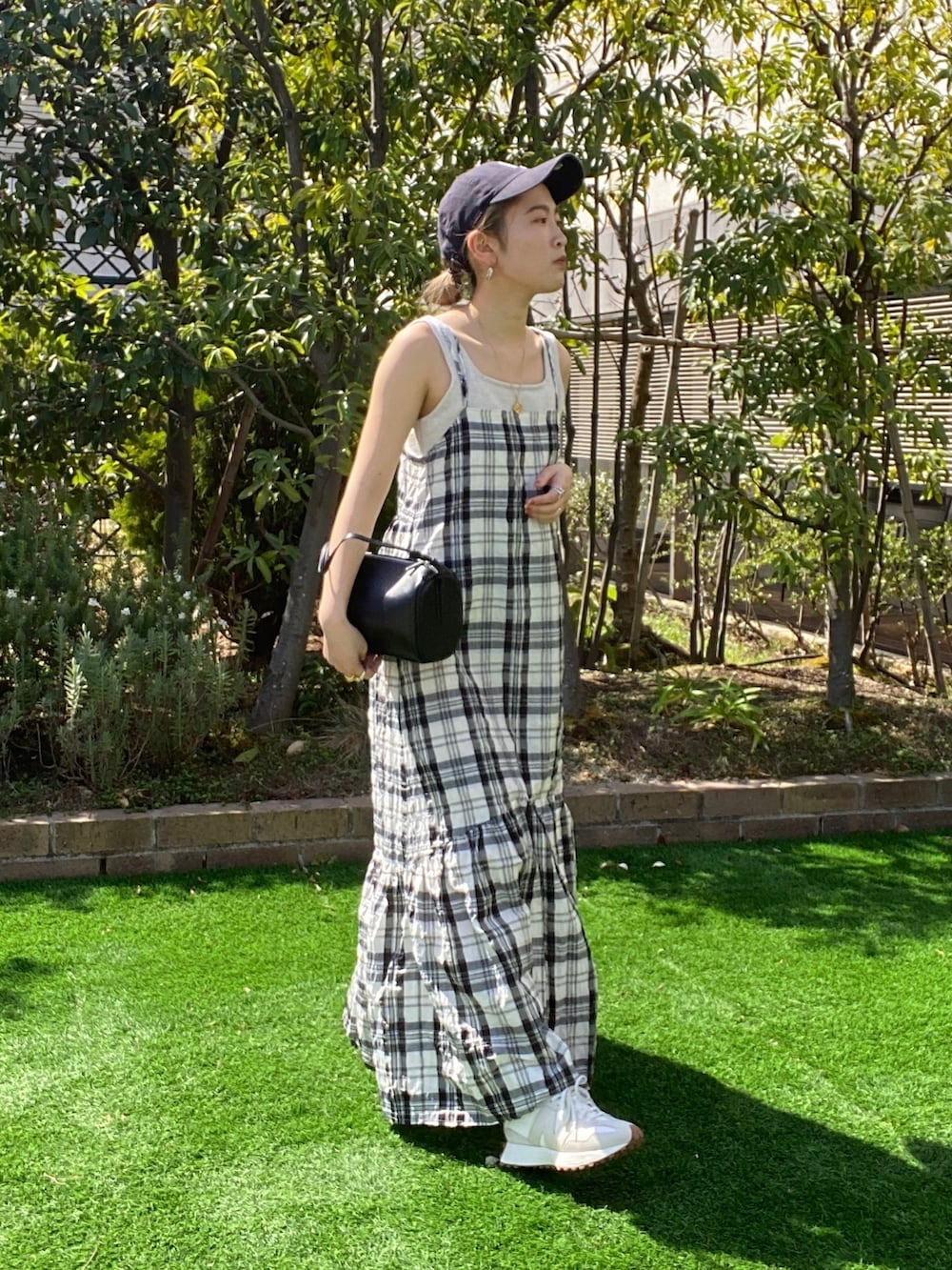 ホワイト系のニット/セーター、ブラック系のワンピース、ブラック系のハンドバッグを着用したレディースの春コーディネートの3枚目の写真