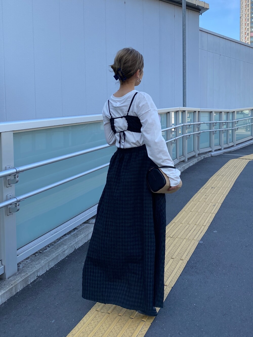 ホワイト系のTシャツ/カットソー、ブラック系のワンピース、ブラック系のブーツを着用したレディースの冬コーディネートの3枚目の写真