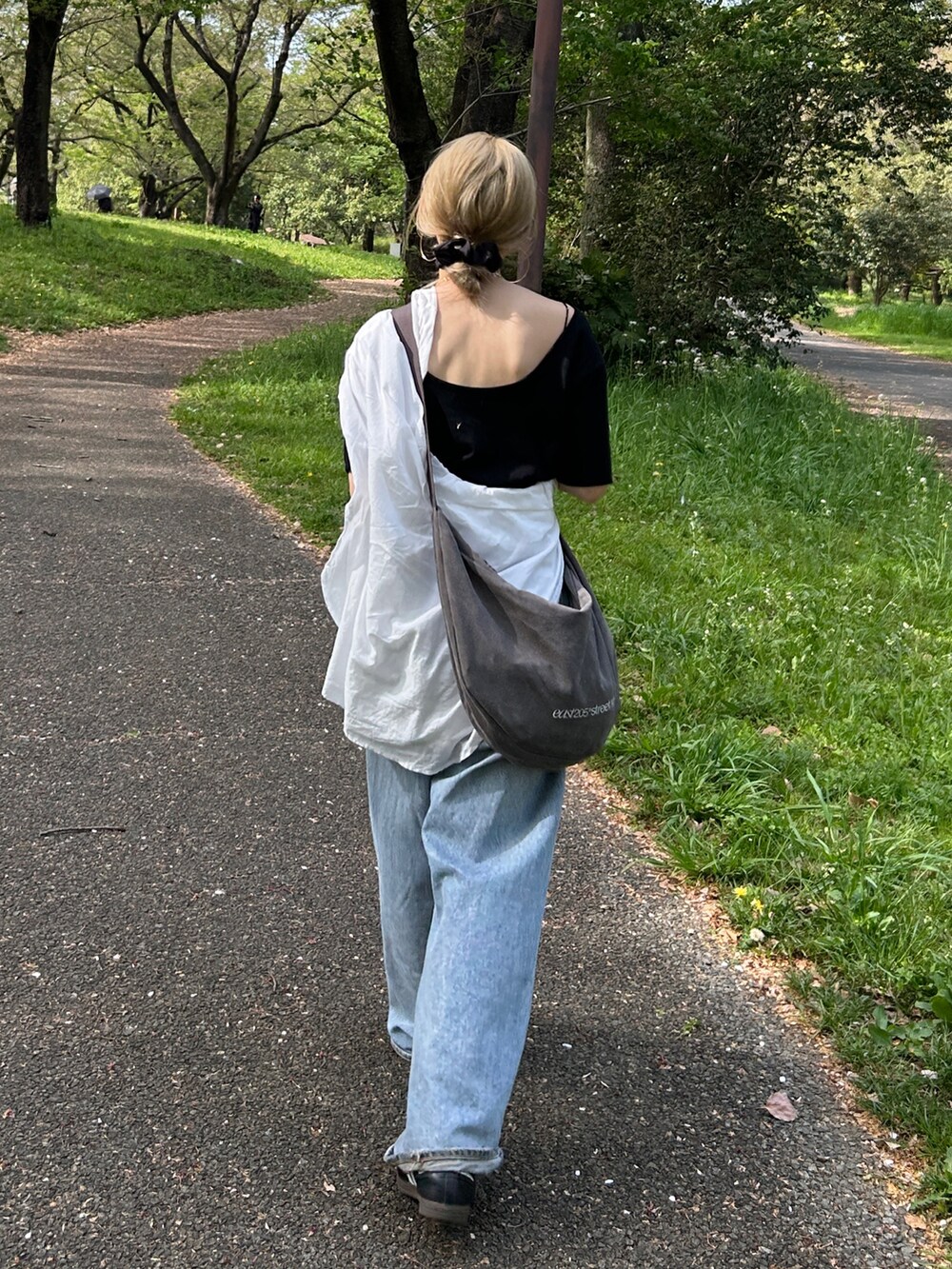 ブラック系のTシャツ/カットソー、ホワイト系のシャツ/ブラウス、グレー系のハンドバッグを着用したレディースの春コーディネートの6枚目の写真