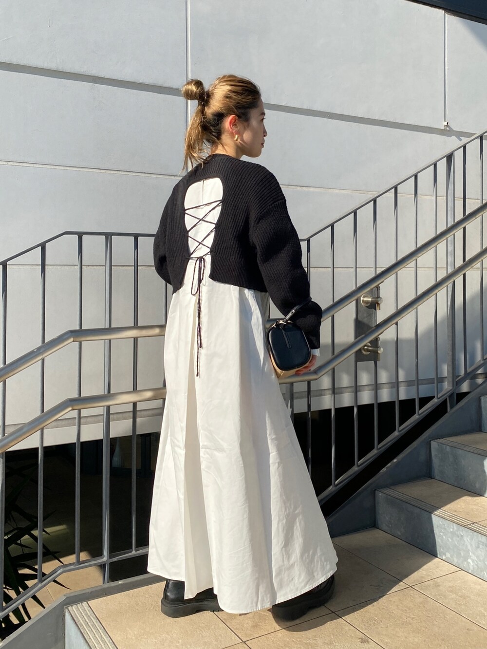 ブラック系のワンピース、その他のハンドバッグを着用したレディースの冬コーディネートの5枚目の写真