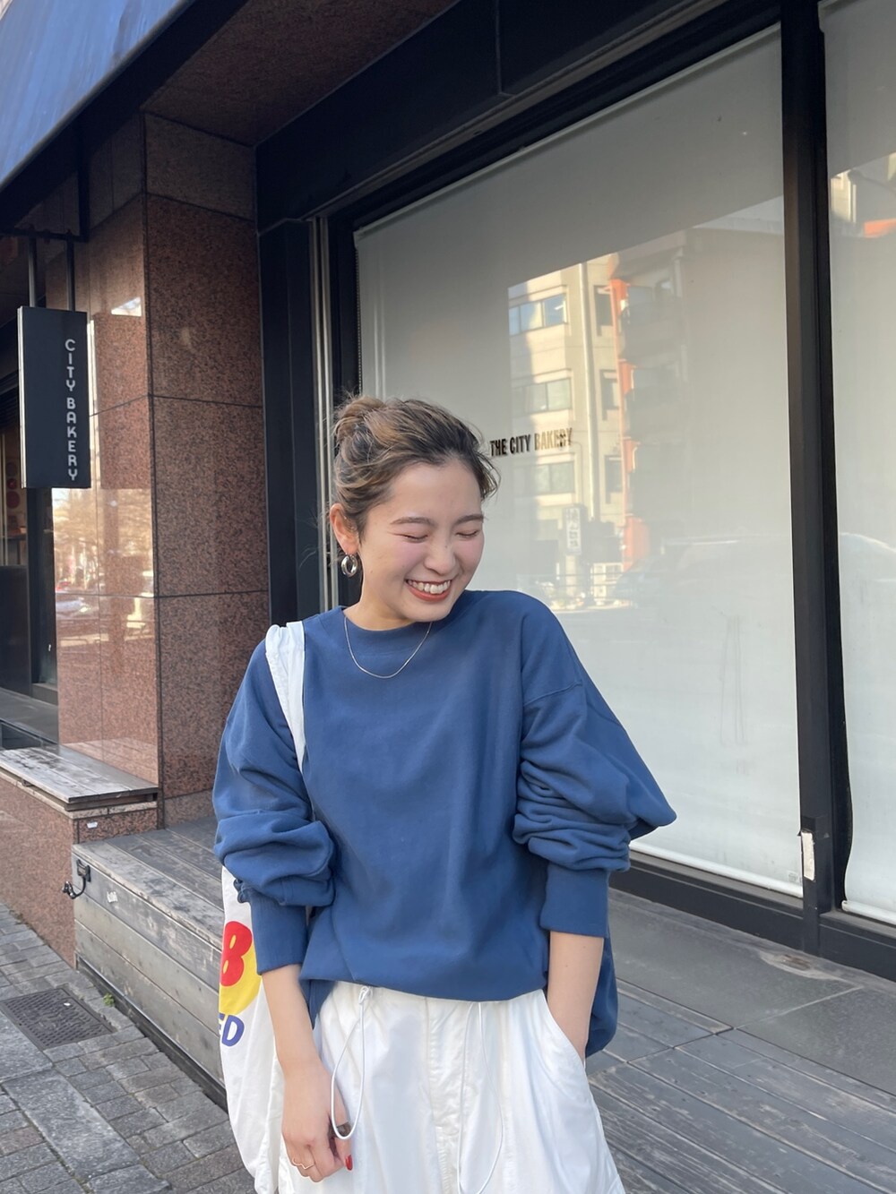 ホワイト系のカーゴパンツ、ブルー系のスウェット、ホワイト系のエコバッグ/サブバッグを着用したレディースの冬コーディネートの4枚目の写真