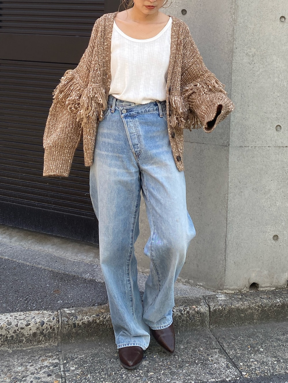 ブラウン系のカーディガン/ボレロ、ブルー系のデニムパンツ、ブラウン系のブーツを着用したレディースの冬コーディネートの6枚目の写真