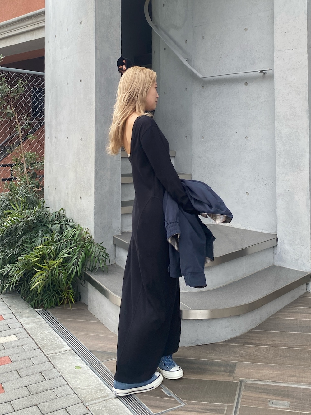 ブラック系のワンピース、ブルー系のスニーカーを着用したレディースの冬コーディネートの2枚目の写真