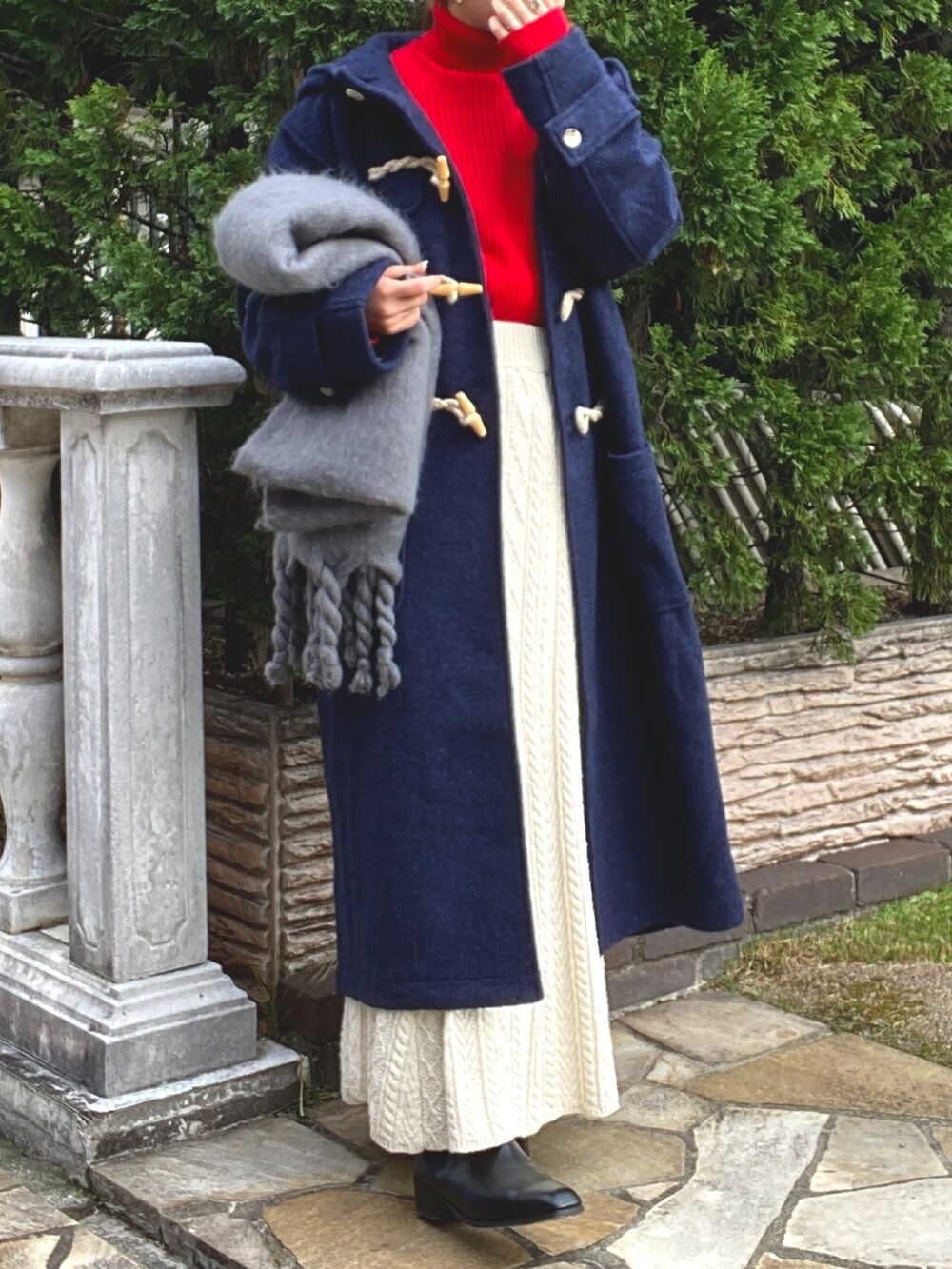 ホワイト系のスカート、ブルー系のダッフルコート、レッド系のニット/セーターを着用したレディースの冬コーディネートの5枚目の写真