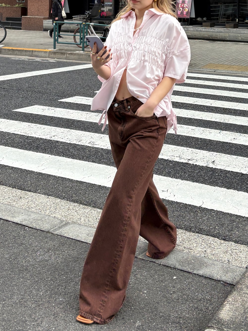 ブラウン系のデニムパンツ、ピンク系のシャツ/ブラウス、その他のサンダルを着用したレディースの春コーディネートの2枚目の写真