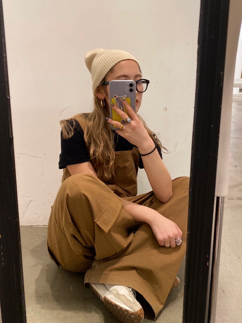 イエロー系のつなぎ/オールインワン、ホワイト系のニットキャップ/ビーニー、ブラック系のメガネを着用したレディースの春コーディネートの4枚目の写真