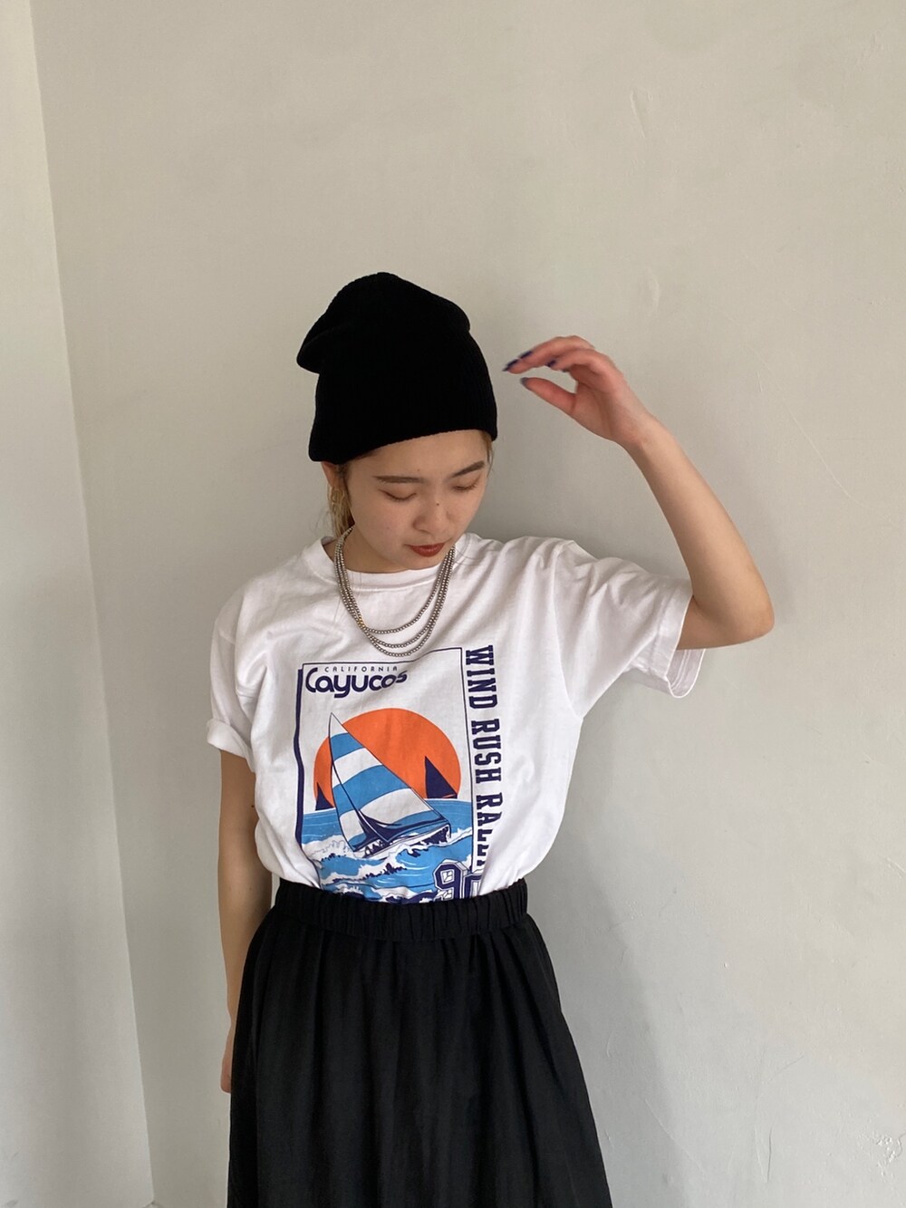 ホワイト系のTシャツ/カットソー、ブラック系のスカートを着用したレディースの春コーディネートの4枚目の写真