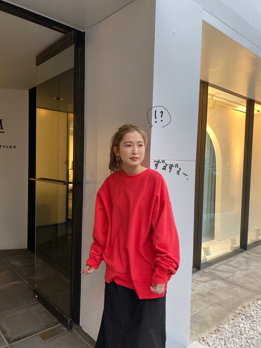 ブルー系のデニムジャケット、レッド系のスウェット、ブラック系のスカートを着用したレディースの冬コーディネートの5枚目の写真