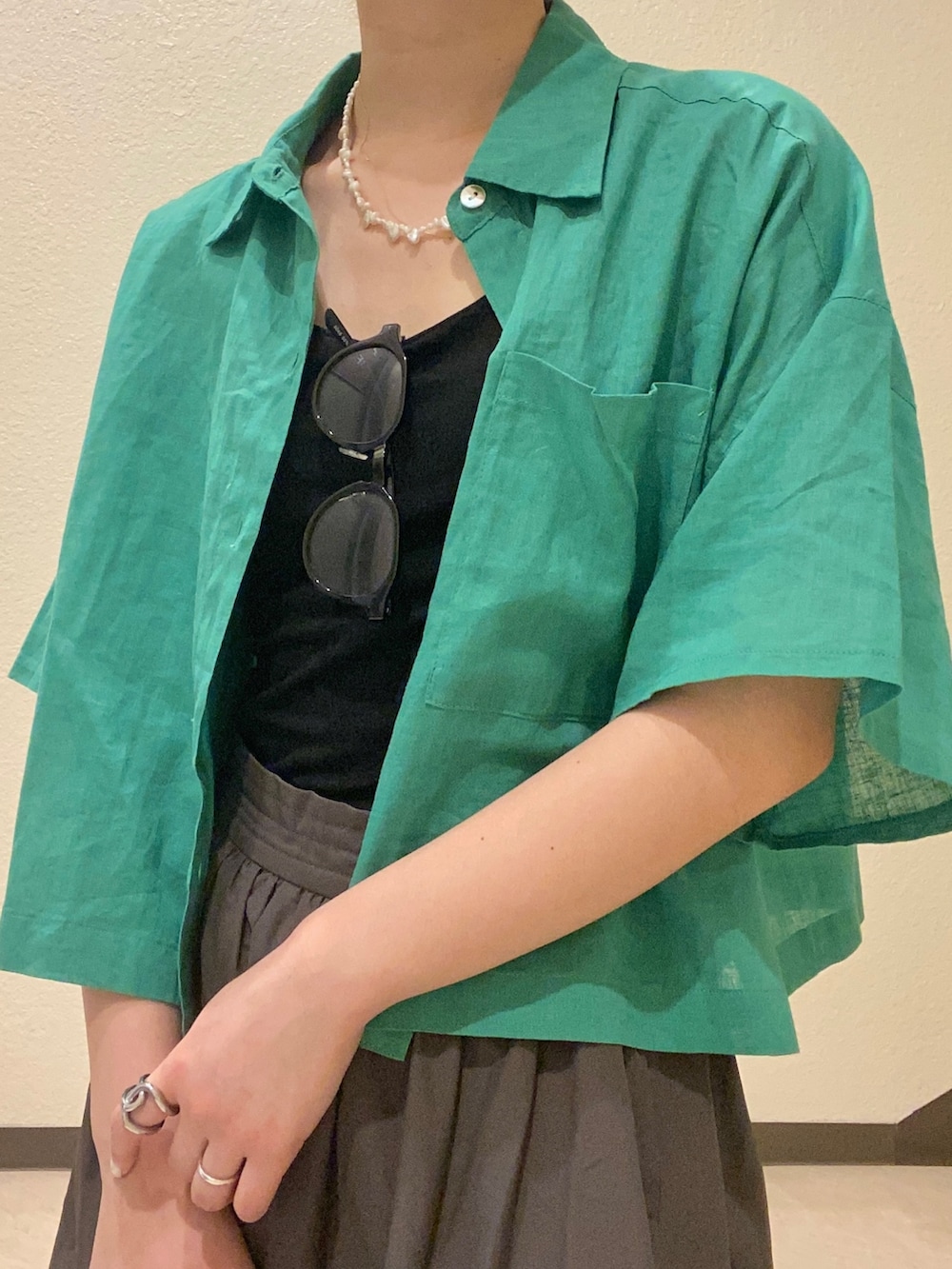 グリーン系のシャツ/ブラウス、グレー系のスカート、ホワイト系のスニーカーを着用したレディースの夏コーディネートの4枚目の写真