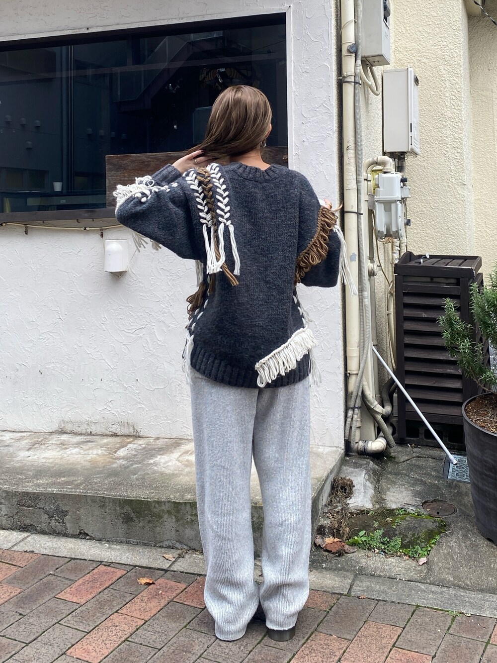 グレー系のニット/セーター、グレー系のその他パンツを着用したレディースの秋コーディネートの5枚目の写真