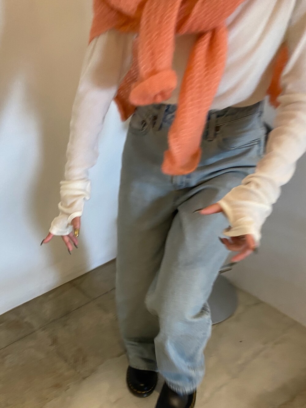 ピンク系のニット/セーター、ホワイト系のTシャツ/カットソー、ブルー系のデニムパンツを着用したレディースの秋コーディネートの4枚目の写真