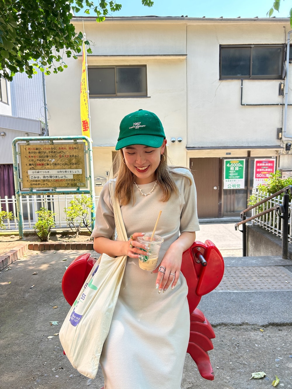 グレー系のワンピース、グリーン系のキャップを着用したレディースの夏コーディネートの7枚目の写真