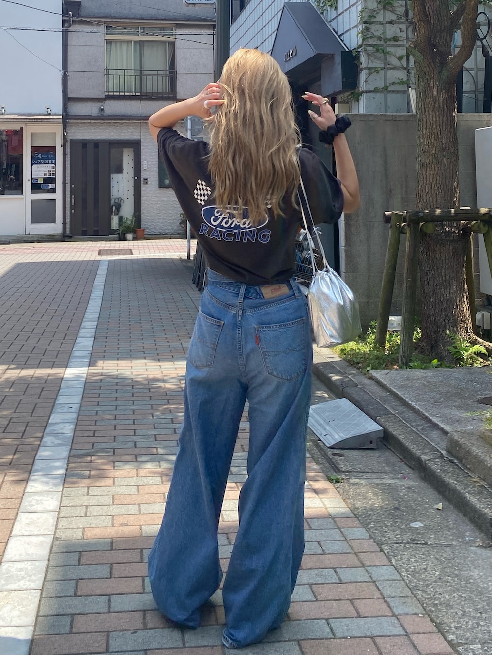 グレー系のTシャツ/カットソー、ブルー系のデニムパンツを着用したレディースの夏コーディネートの3枚目の写真